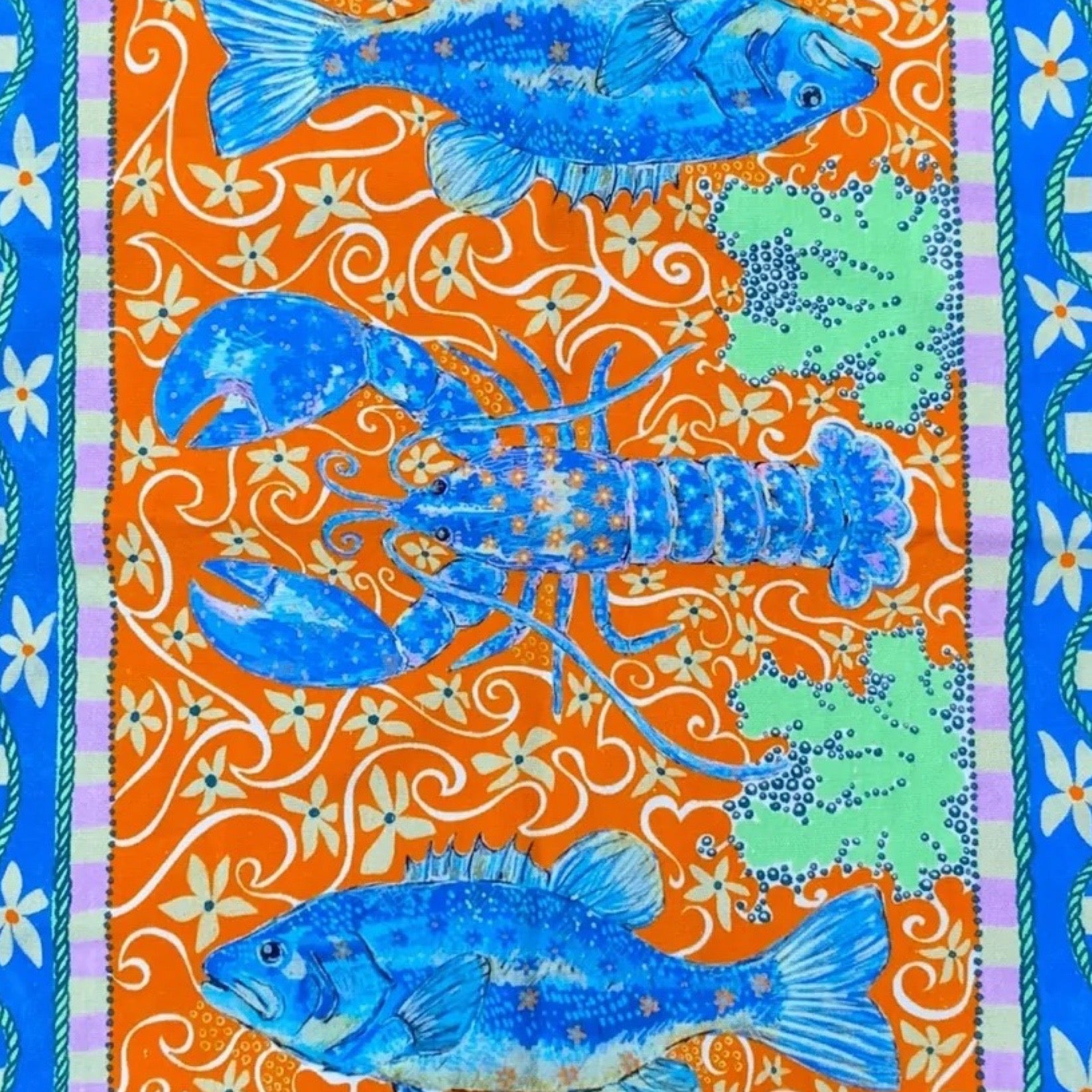 Close up of a lobster design tea towel with a blue and orange design.