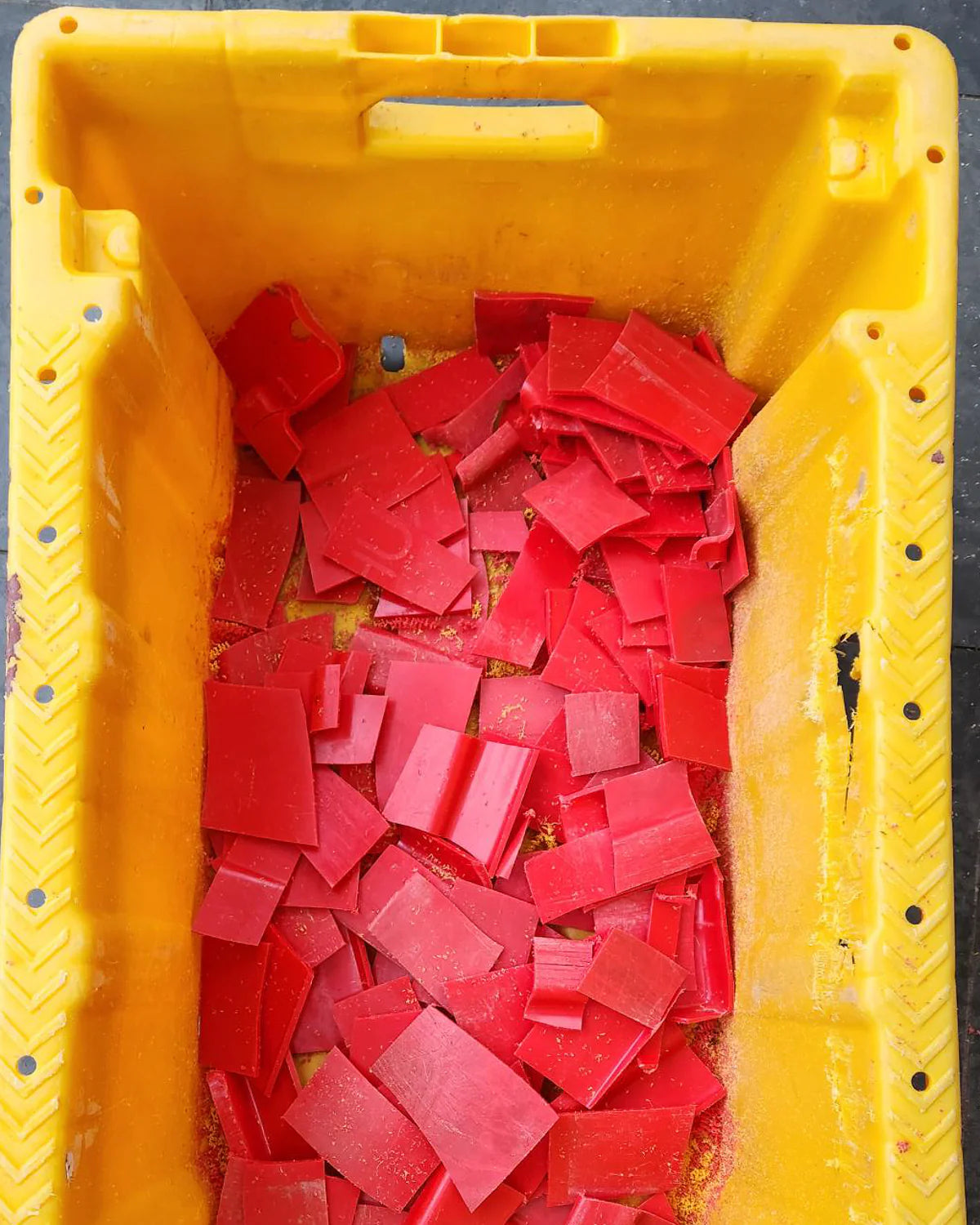 Yellow container filled with red square blocks.