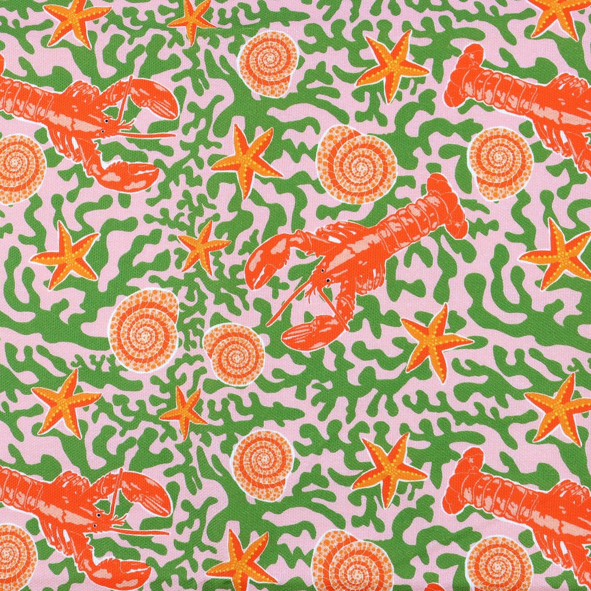 Section of tea towel featuring an illustration of lobsters, starfish and shells on a seaweed background.