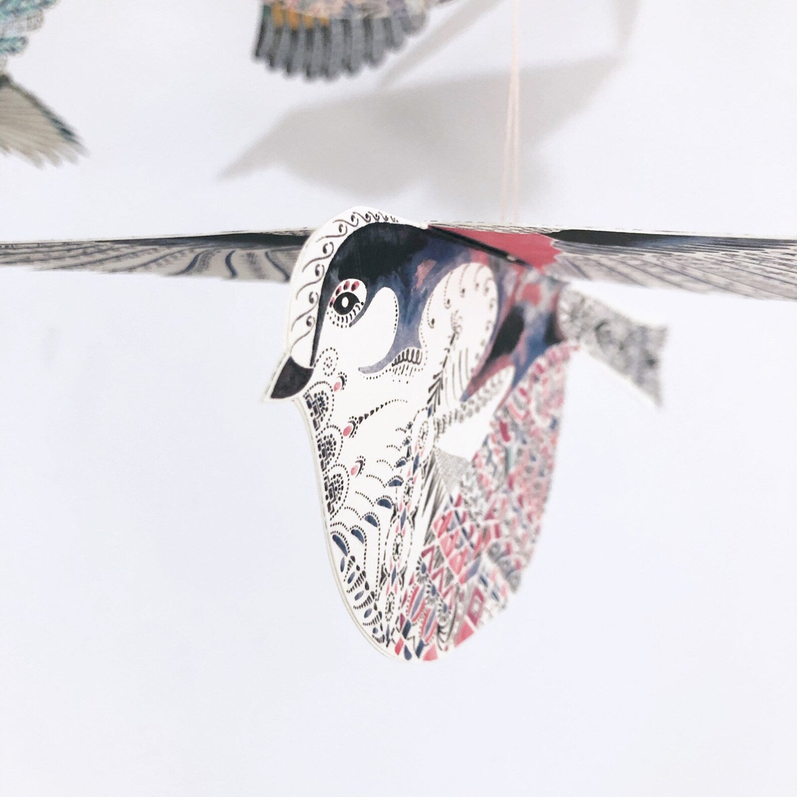 Decorative paper swan with intricate patterns on a white background.