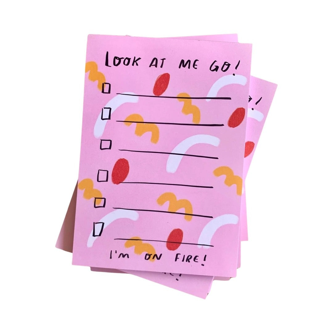 Colorful list pad with pink background and red, white, and orange shapes and text that reads 'Look At Me Go, I'm on Fire!'