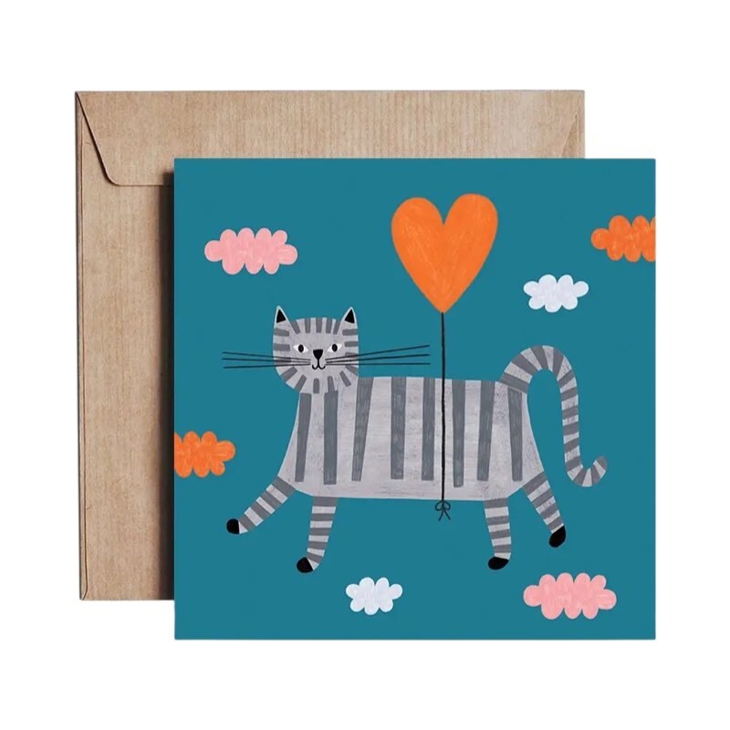 Card featuring an illustration of a grey-striped cat floating tied to a heart-shaped balloon against a teal background.