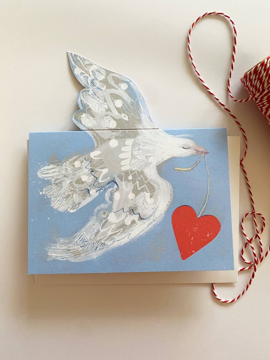 Card with a dove and heart design on a light background.