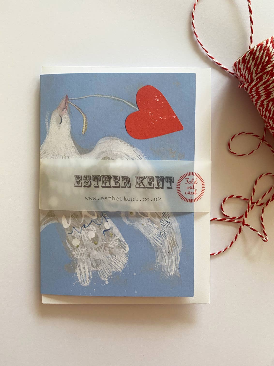 Greeting card with dove and heart design by Esther Kent on a light background.