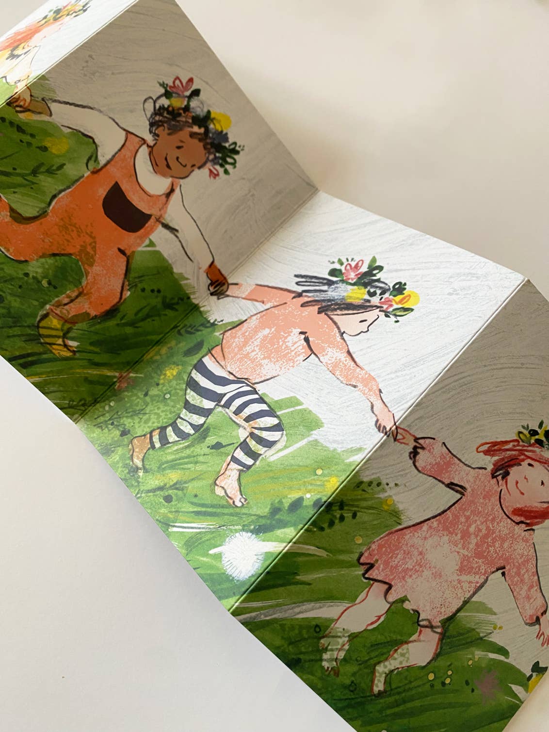 Illustrated card with characters and animals on a white surface.