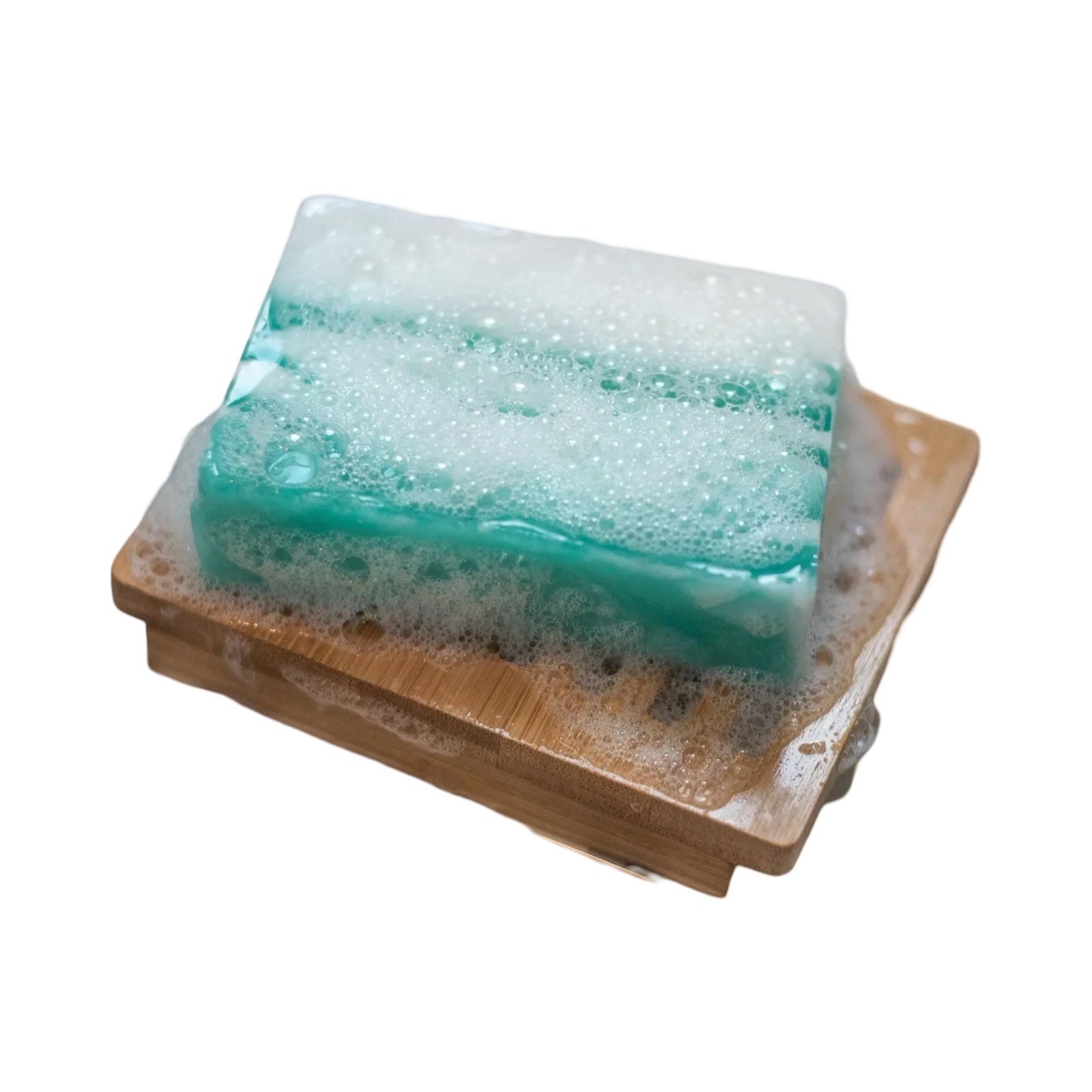 A bar of green and white meditation soap sitting on a wooden soap dish.