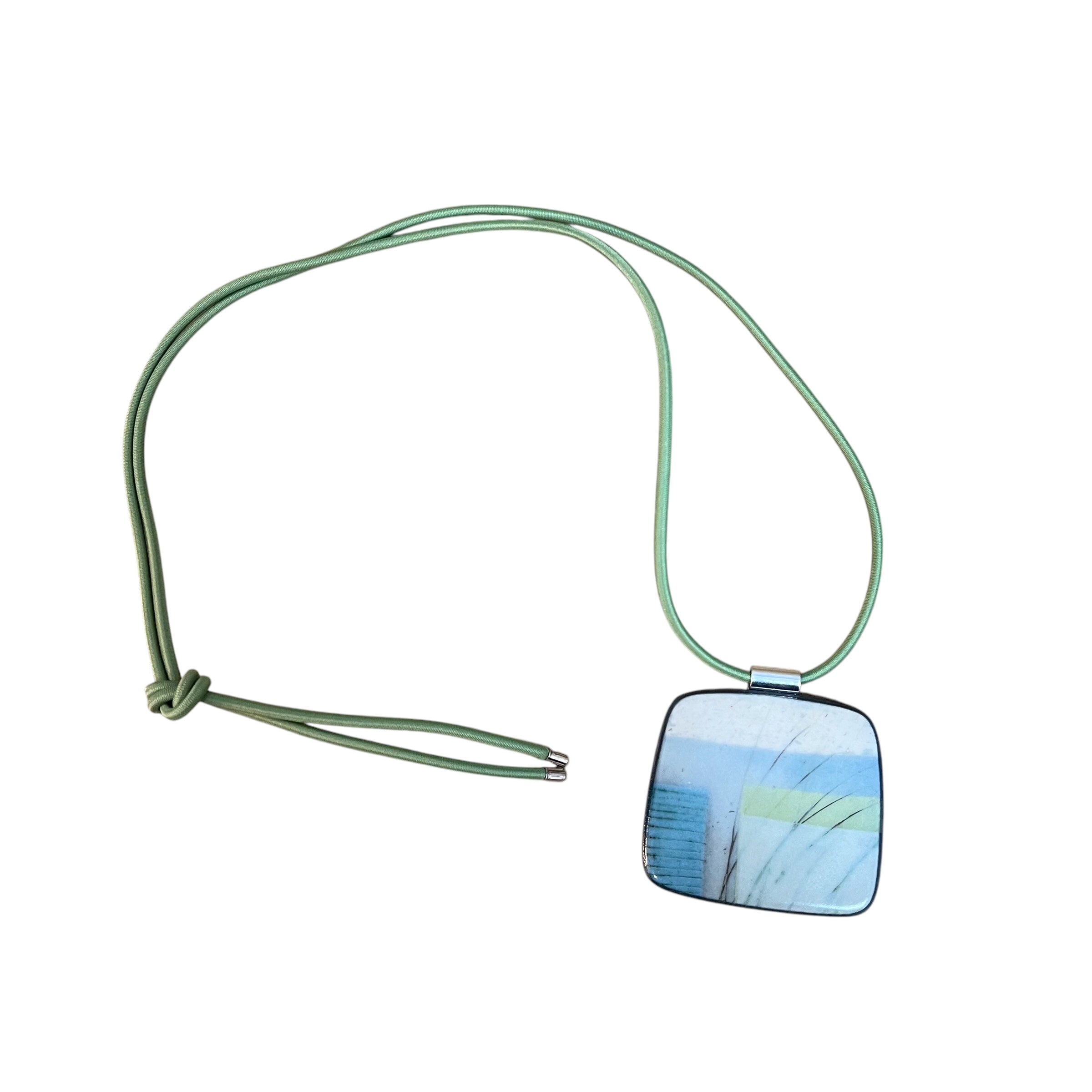 This pendent necklace is made from black porcelain casting slip layered with a white decorating slip and a ceramic decal, it is a wearable piece of art! The brooch features a turquoise, grey and cream abstract pattern, inspired by nature