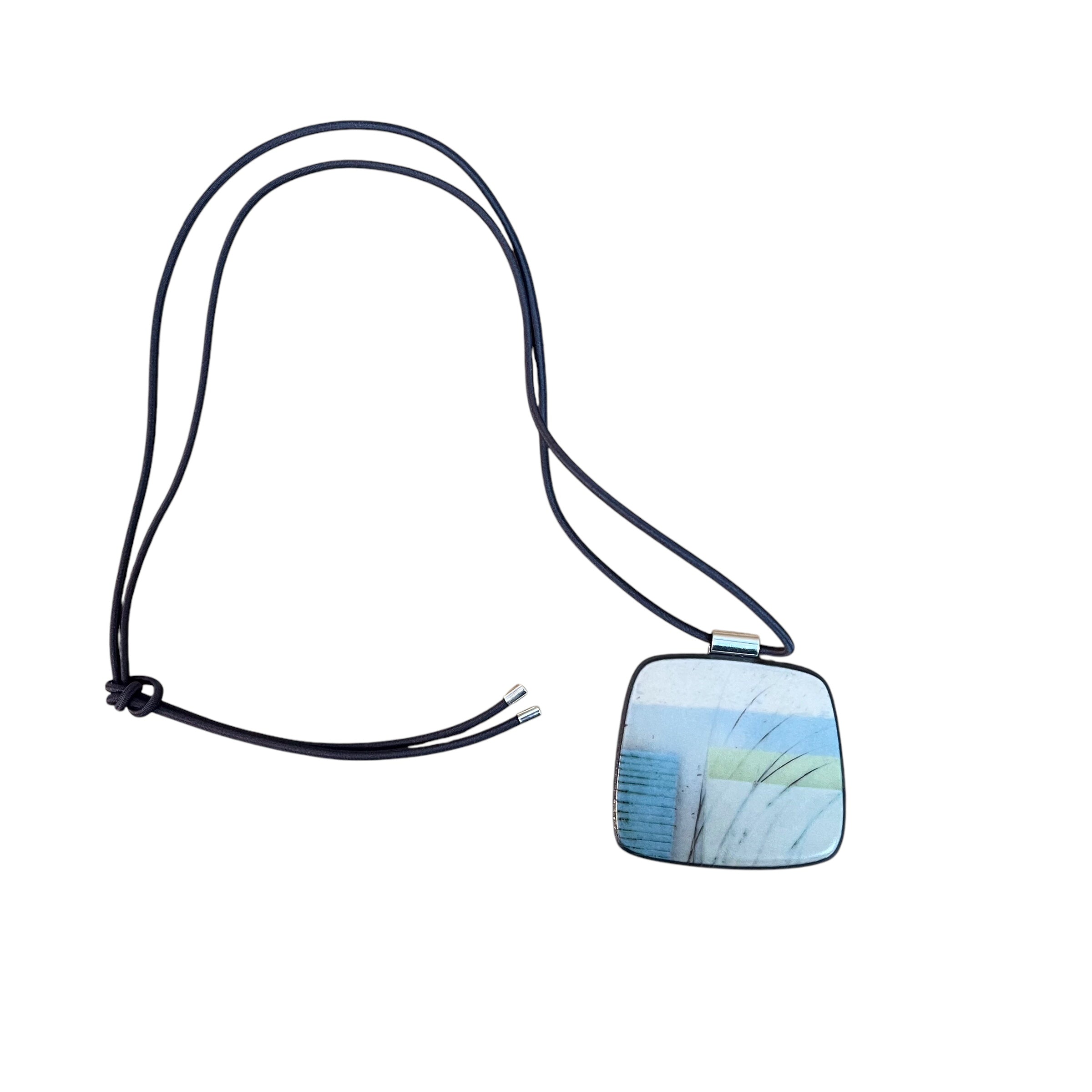 This pendent necklace is made from black porcelain casting slip layered with a white decorating slip and a ceramic decal, it is a wearable piece of art! The brooch features a turquoise, grey and cream abstract pattern, inspired by nature