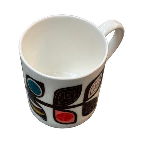 A white fine-bone china mug featuring a midcentury-inspired colourful leaf stem.