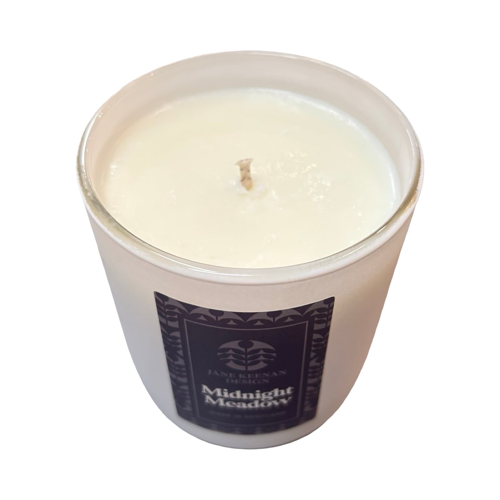 A white wax candle in a white glass jar with a navy label reading 'Midnight Meadow' on a white background.
