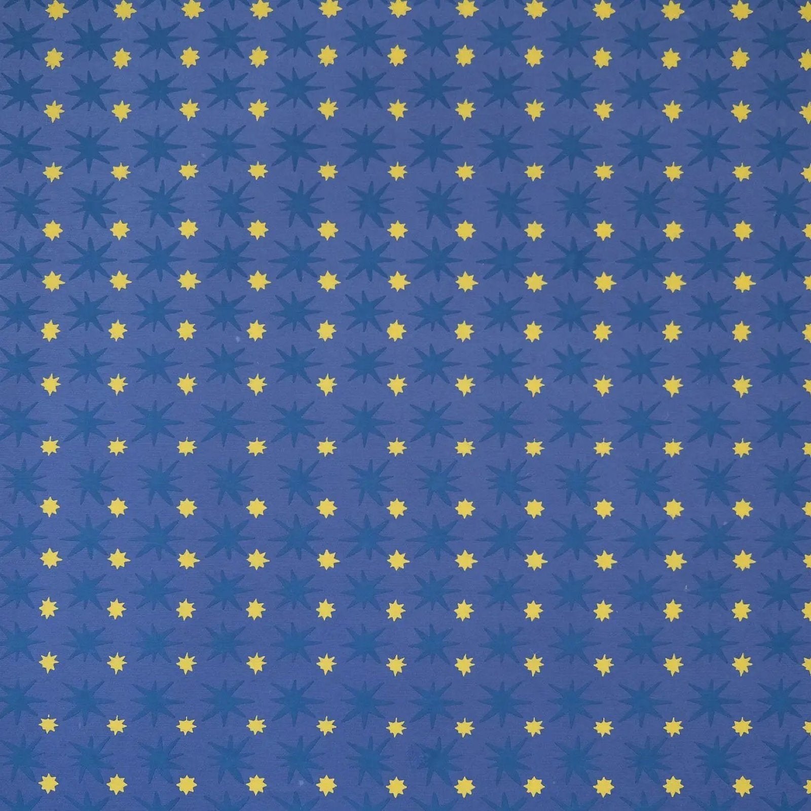 Wrapping paper with large dark blue stars and mini yellow stars against a midnight blue background