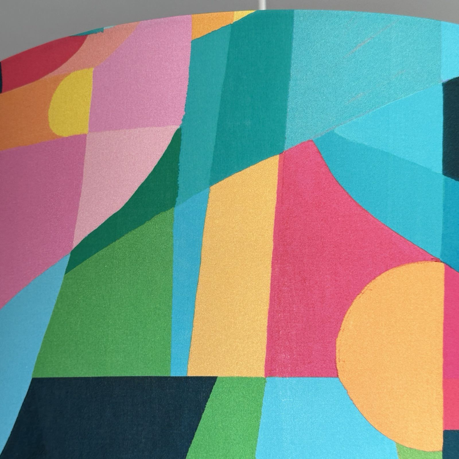 bright cotton fabric with abstract geometric shapes in turquoise, navy, pink, yellow and green