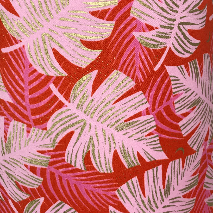 Red cotton fabric with giant pink monstera leaves with gold details.