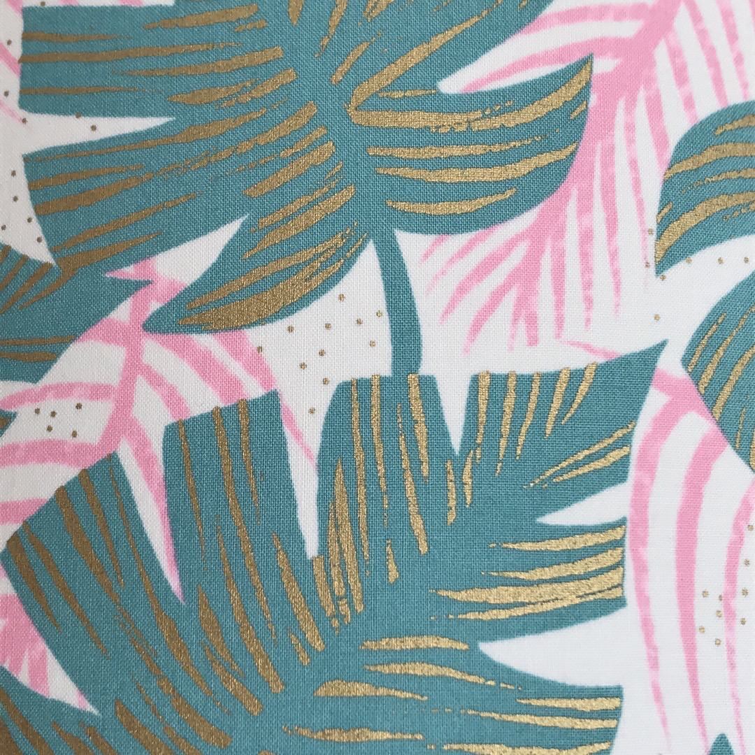 White fabric with green and pink leaves and gold detail.