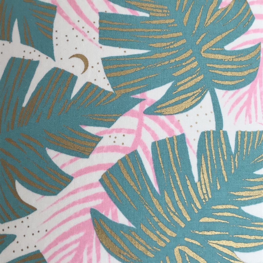 White fabric with green and pink leaves and gold detail.