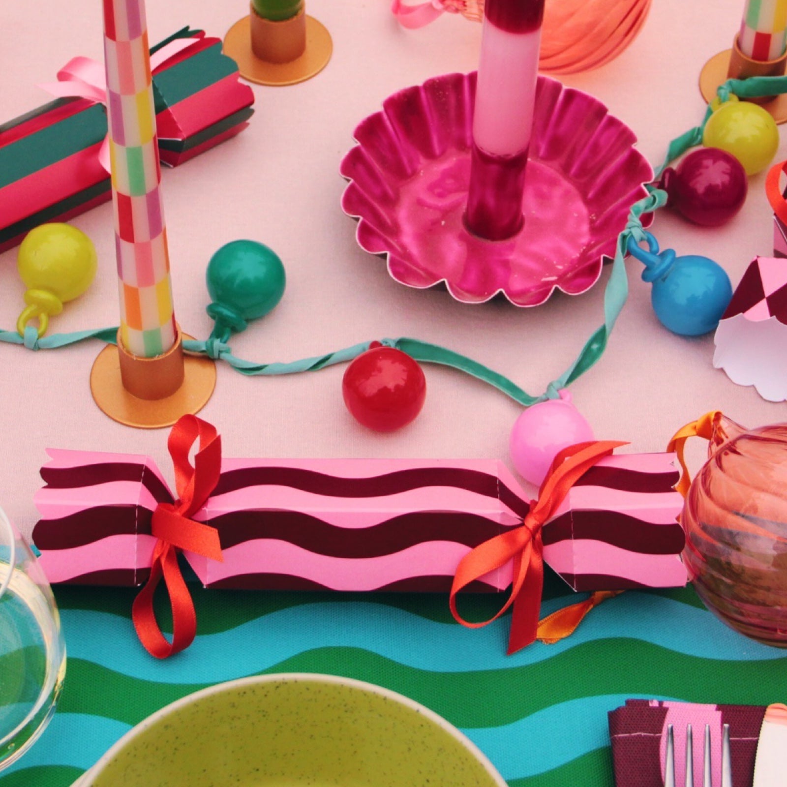 Colourful Christmas cracker on decorated table.