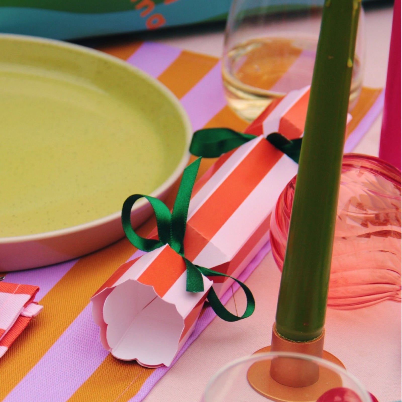 Colourful Christmas cracker on decorated table.