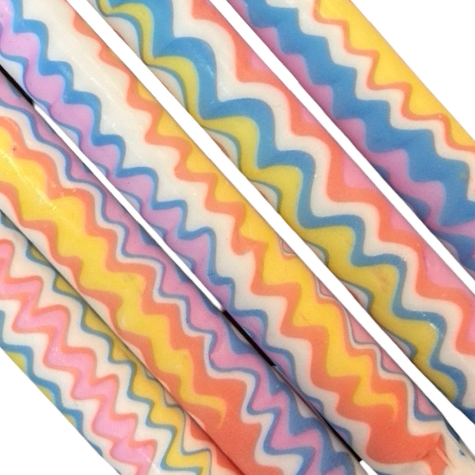 A row of five handmade dinner candle marbled in a blue, pink, yellow and orange in a zig zag pattern on a white background.