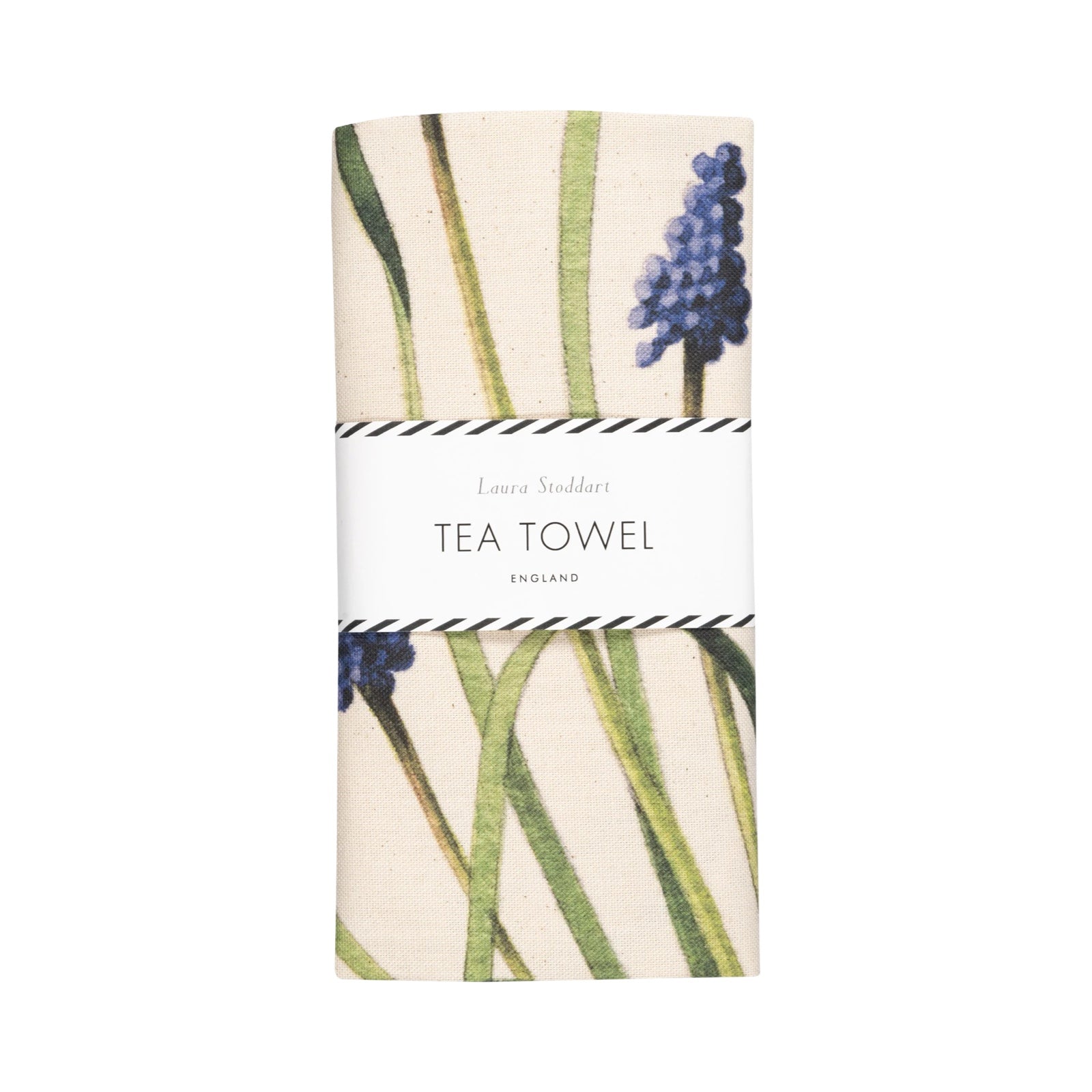 A tea towel featuring an illustration of a lady dressed in a yellow shirt, white apron and black skirt holding a giant bunch of purple muscari flowers folded in a white belly band.
