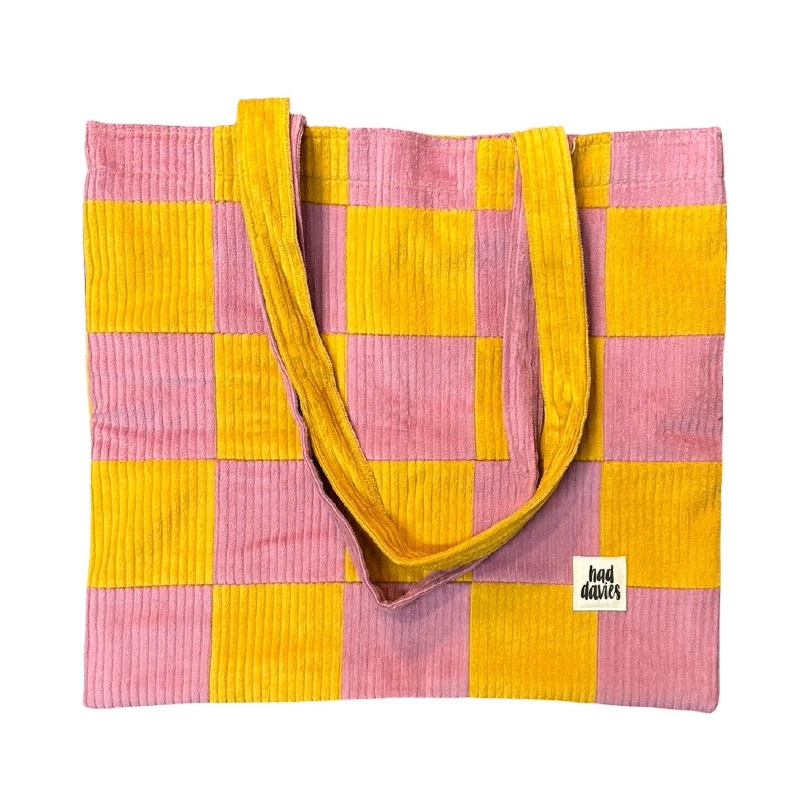 Pink and yellow checkered tote bag with a visible brand label on a white background.