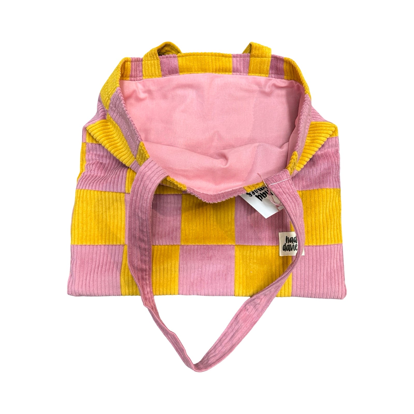 Pink and yellow checkered bag with a pink interior on a white background.