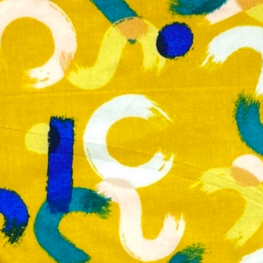 A yellow bandana bib with mustard brush strokes pattern designed for babies.