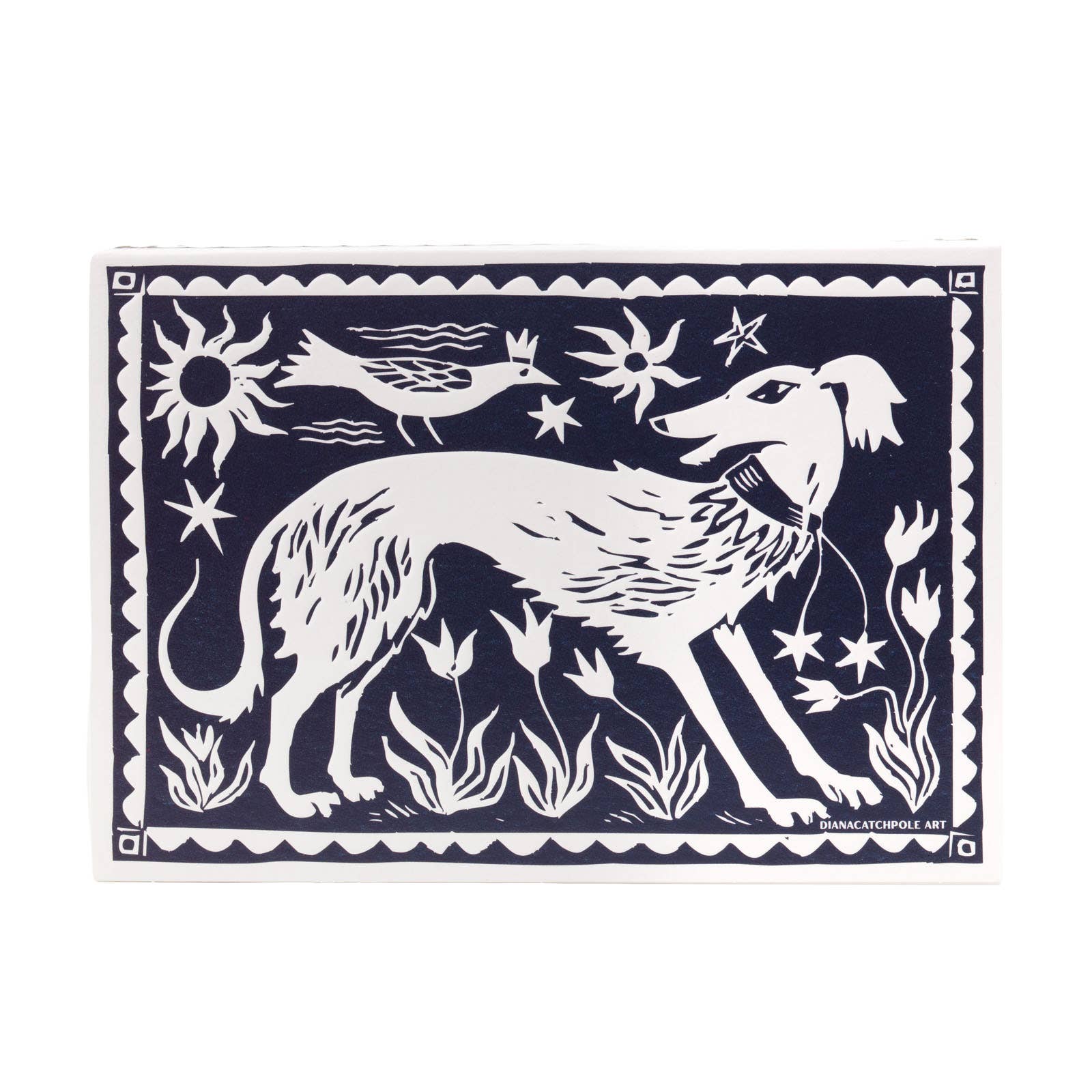 Decorative matchbox with white dog silhouette and nature elements on a dark blue background.