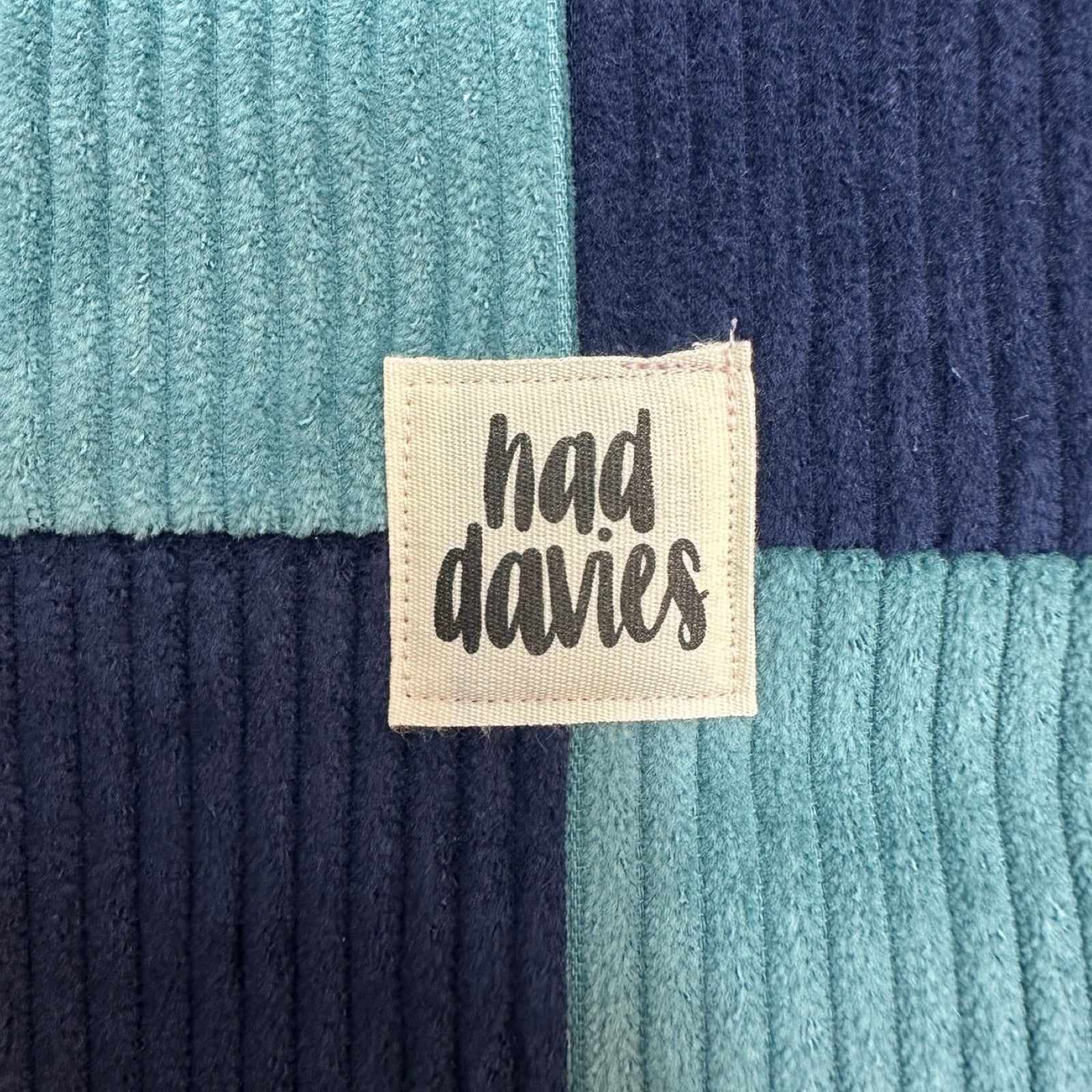 Textile product with 'had davies' label on a textured fabric background.