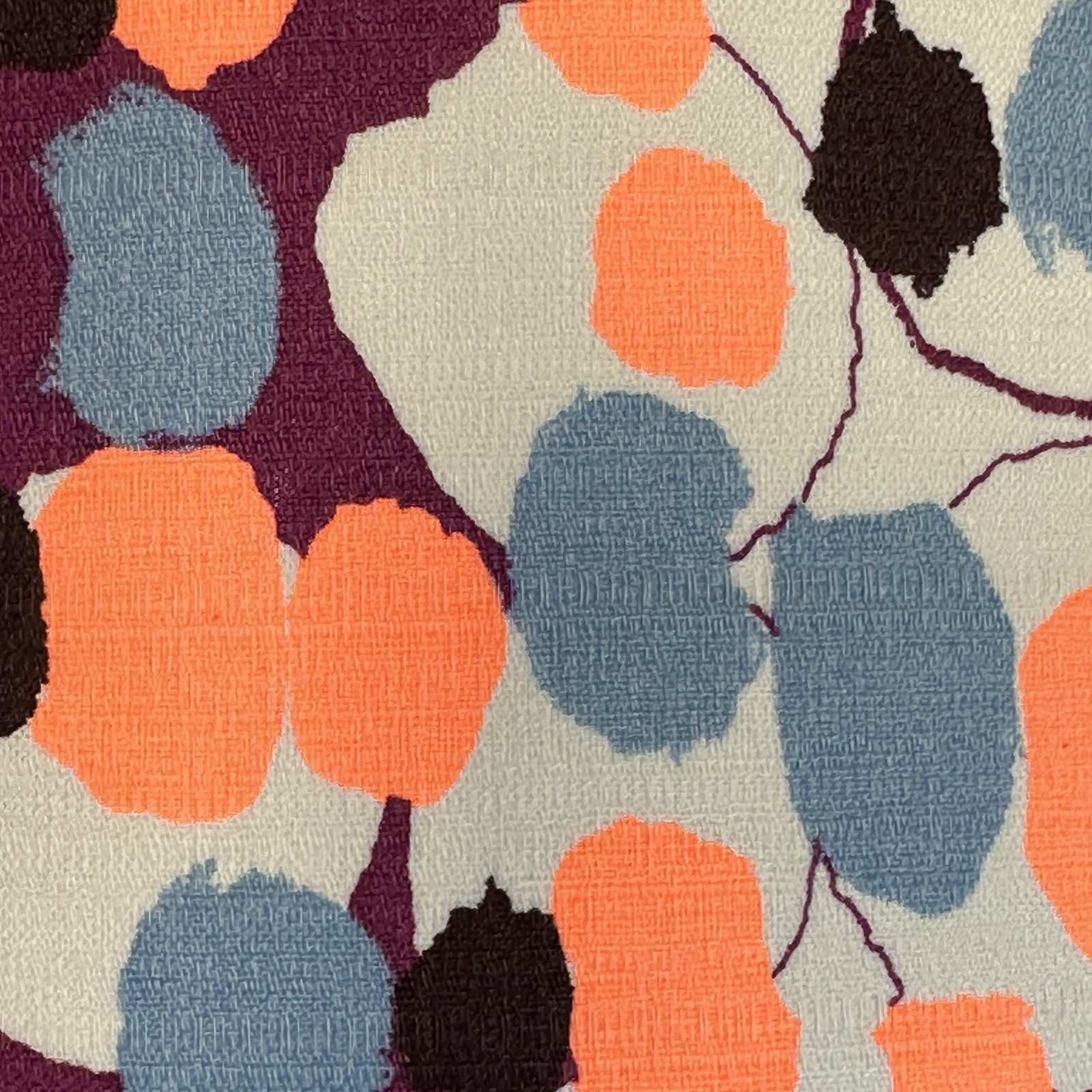barkcloth fabric with neon orange and blue blossoms on a purple and cream background.