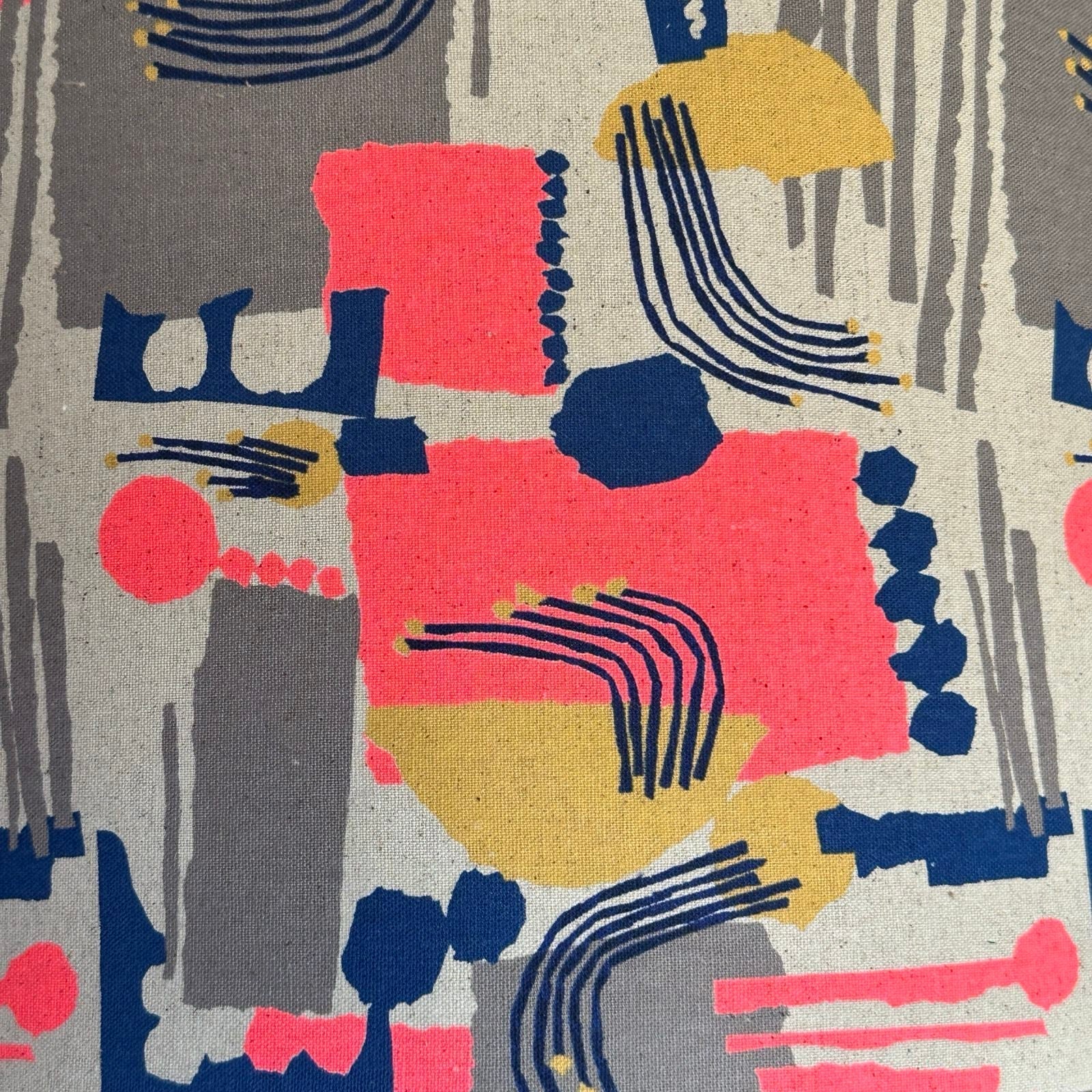 Cotton/linen blend fabric with an abstract shapes pattern in neon pink, navy, gold and grey.