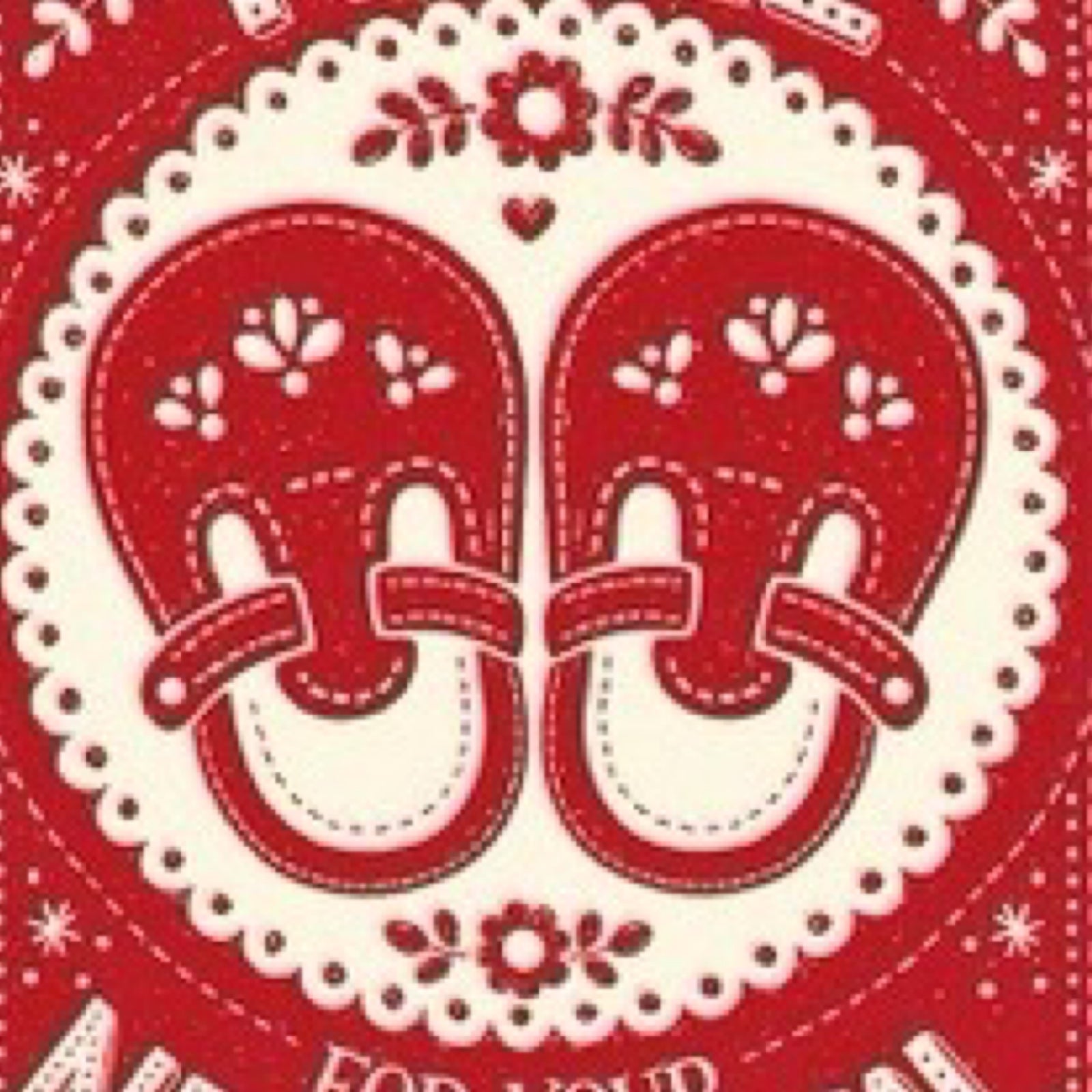 Red and white baby booties with floral patterns on a red background.