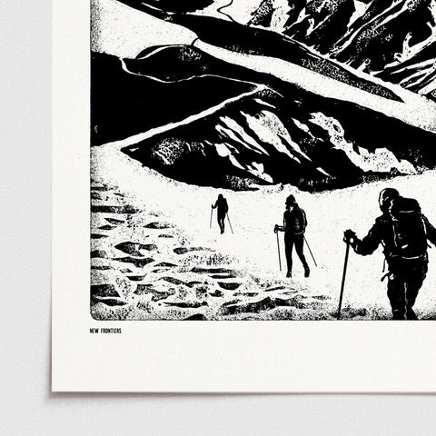 Black and white print featuring a group of hikers climbing up a mountain path in the snow, and a mustard-coloured sun setting behind the mountains.