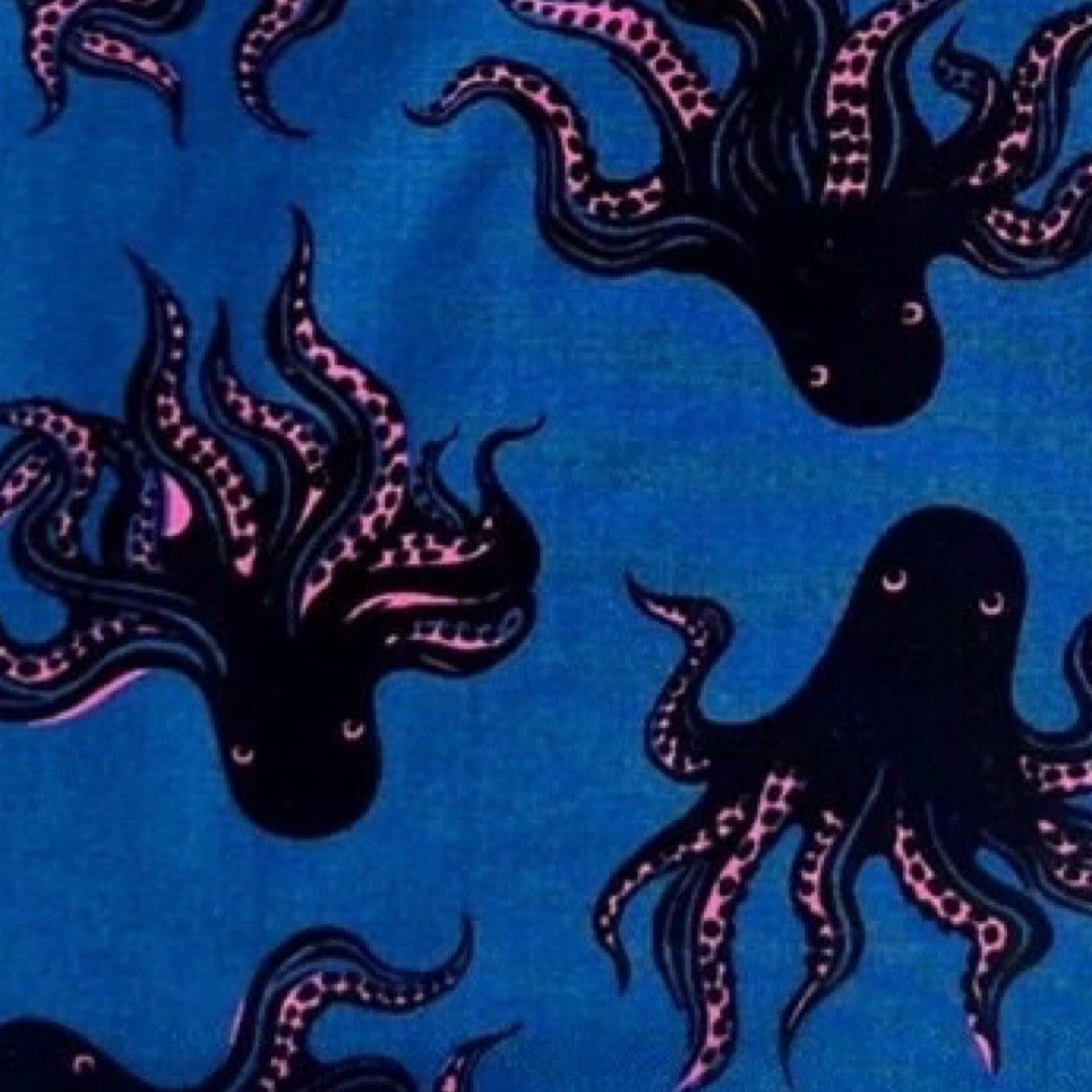 Traditional style bib in octopus fabric with adjustable neck fasteners.