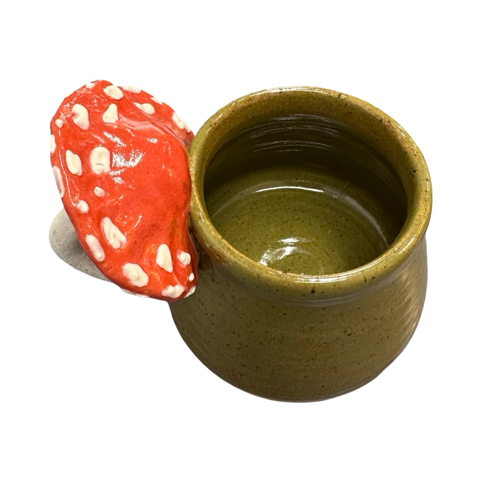 Green ceramic mug with a red mushroom-shaped handle on a white background.