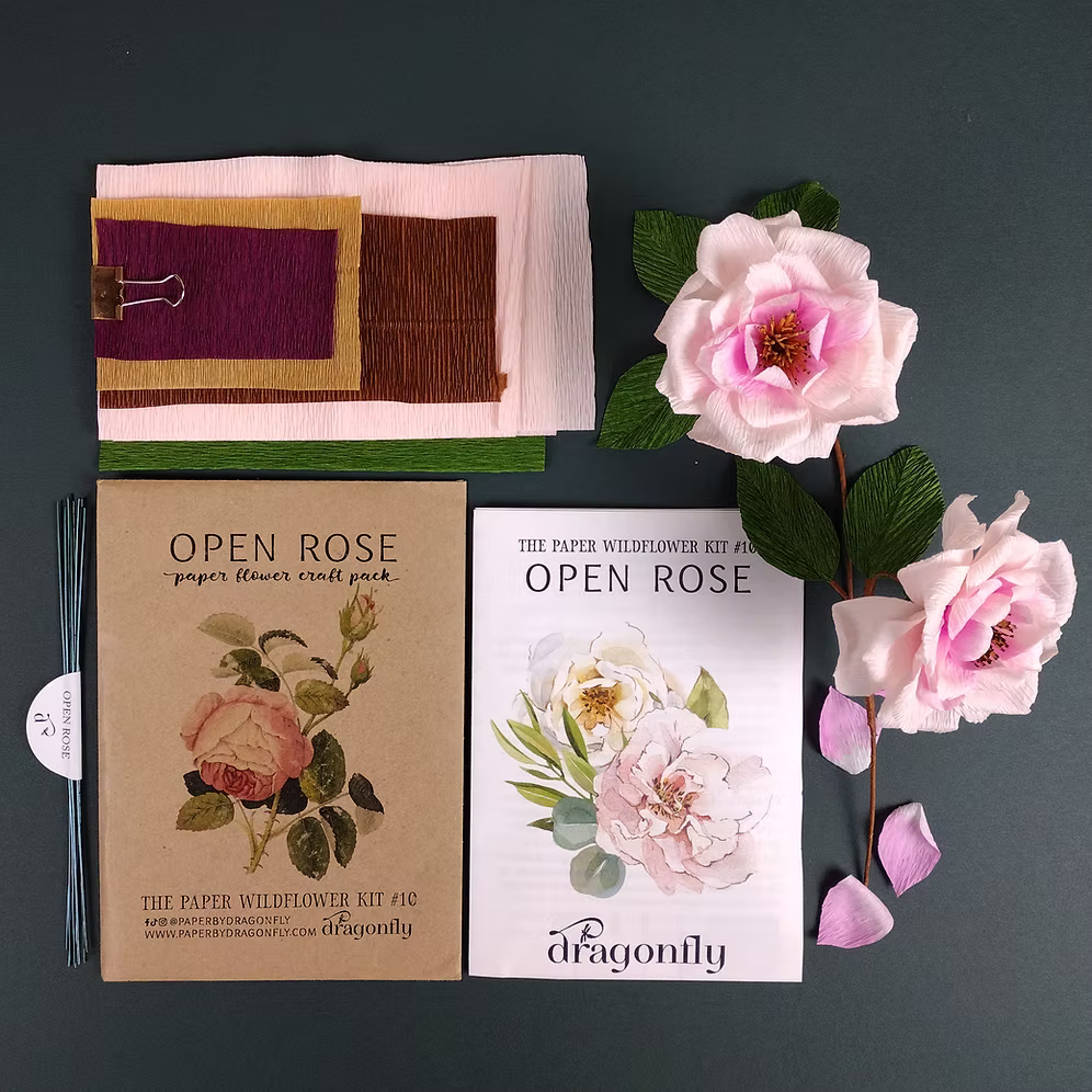 Open Rose paper flower craft pack with flowers and packaging on a dark background.