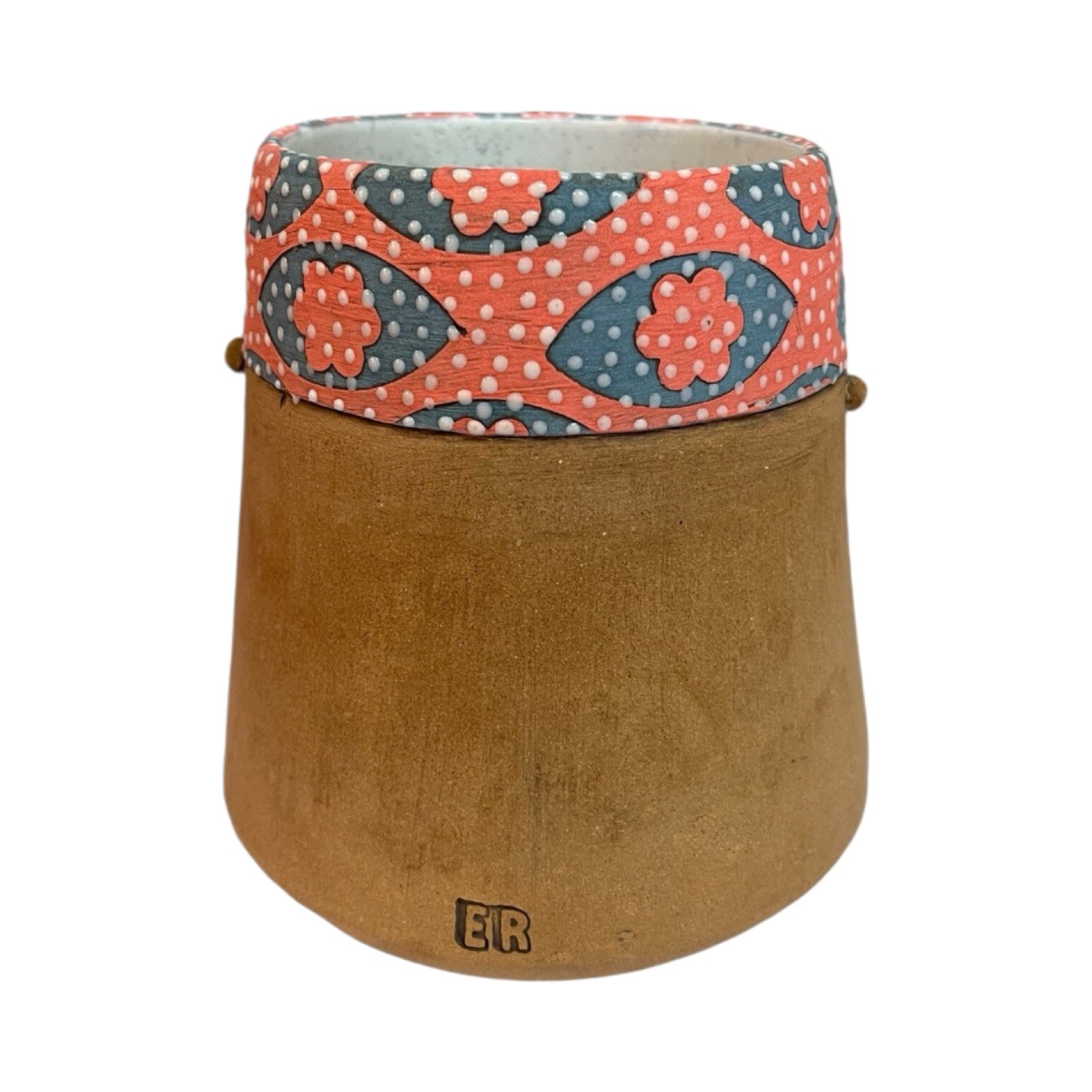 The back of a ceramic beaker with a male moustached face and a red and blue floral pattern.
