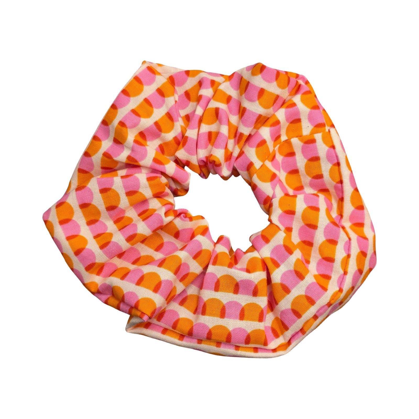 This handmade hair scrunchie is made from 100% cotton fabric with an orange and pink scalloped pattern.