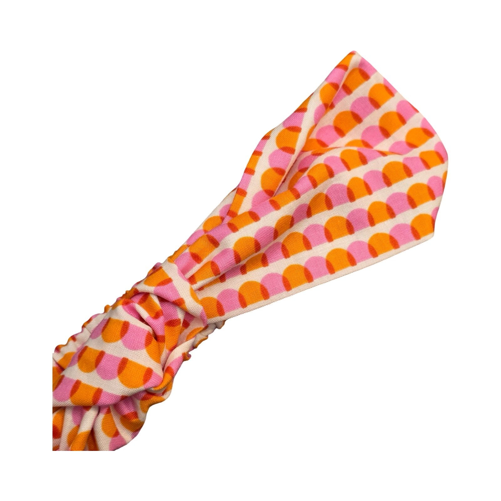 This handmade knotted headband is made from 100% cotton fabric with an orange and pink scalloped pattern.