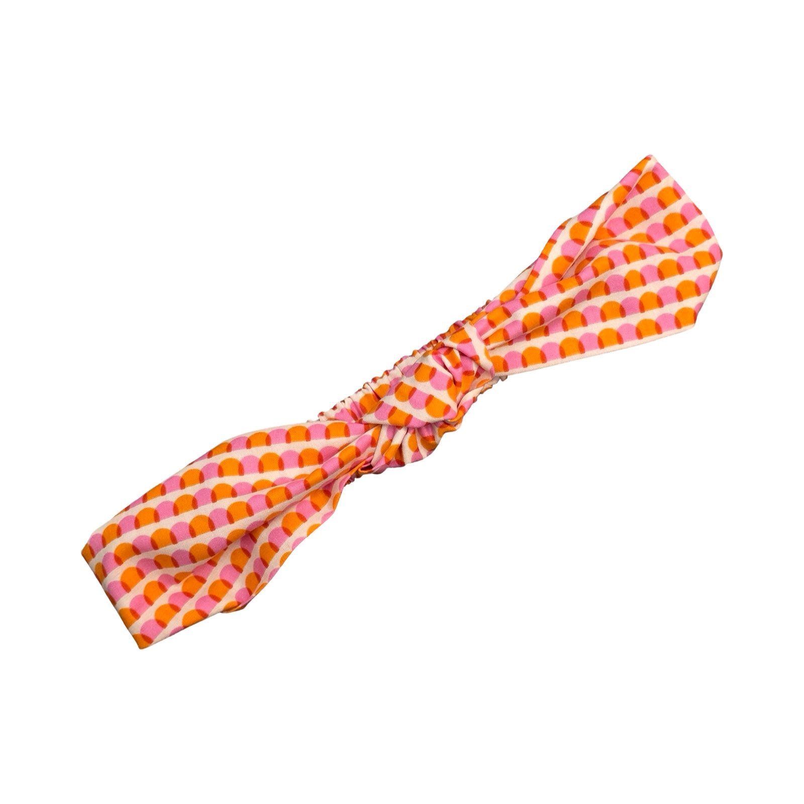 This handmade knotted headband is made from 100% cotton fabric with an orange and pink scalloped pattern.