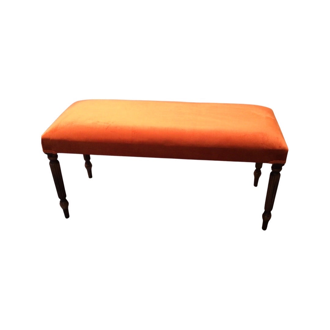 A rectangular velvet bench with mahogany stained legs in a orange colour design.