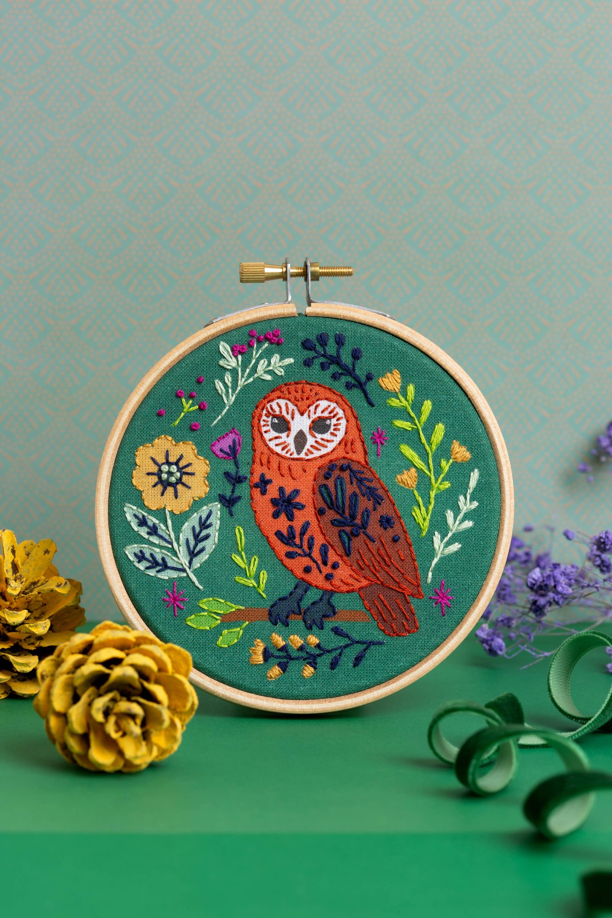 Embroidery hoop with an owl design on a green background.