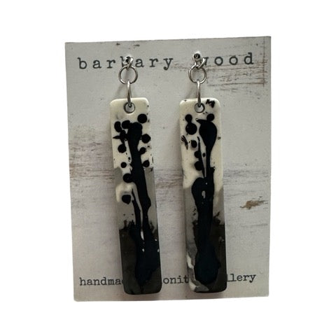 A pair of long rectangular earrings in a blue, grey, black and white paint design on silver ear hooks.