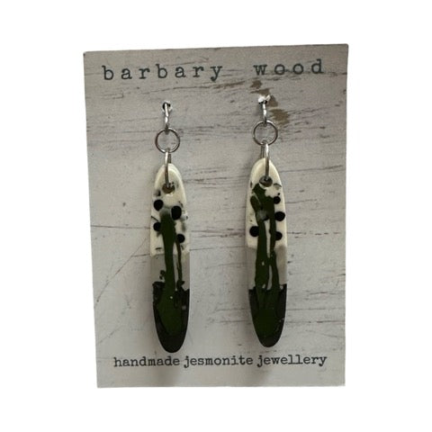 Long thin oval shaped earrings in a green, grey, back and white paint design with silver ear hooks.