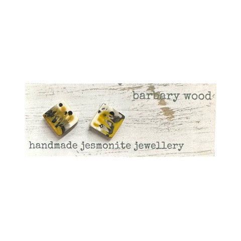 Square stud earrings in a mustard, grey, black and white paint design with silver ear posts.