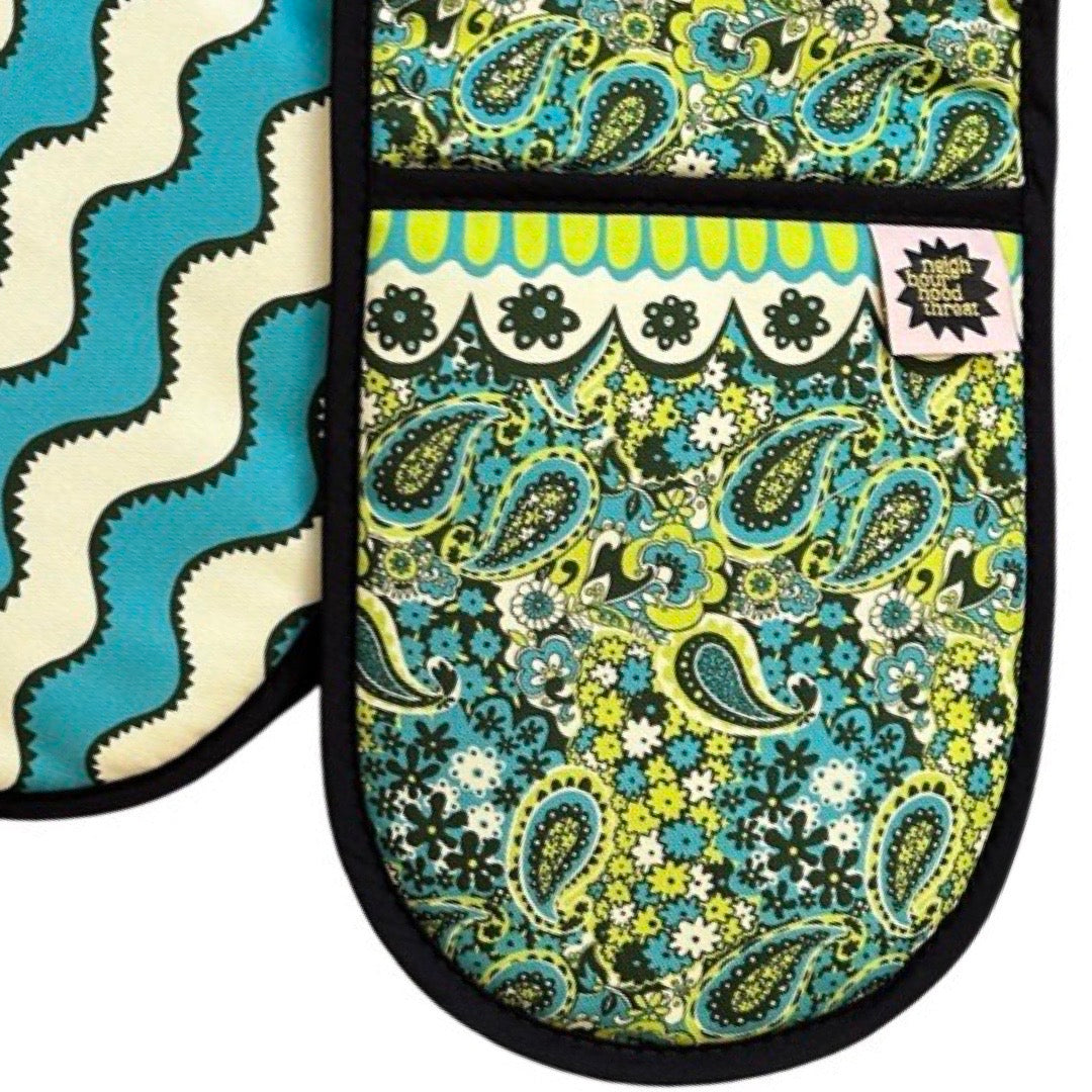 Green and blue paisley pattern design oven gloves with turquoise and cream wiggly stripes on the reverse.
