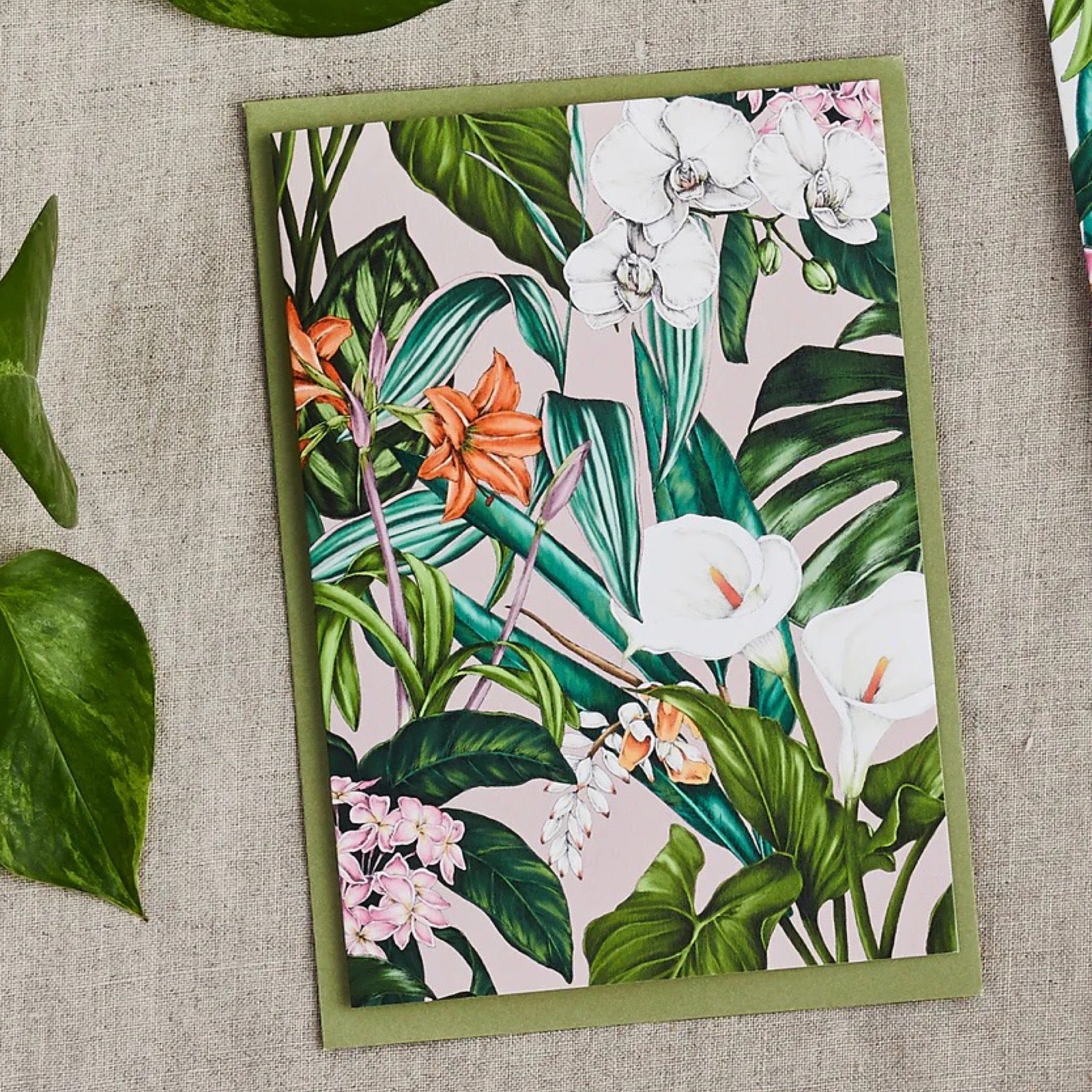 Floral card with green border on a textured surface.