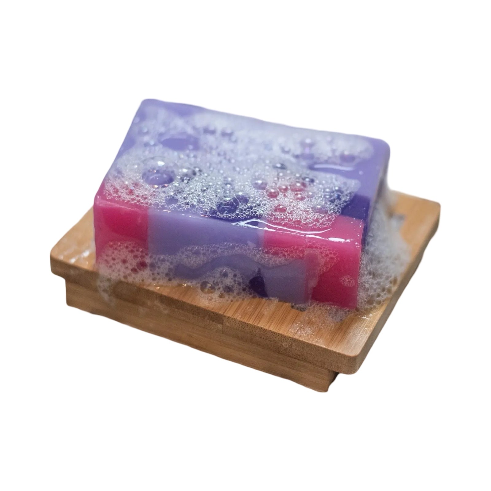 A bar of purple and pink parma violet soap sitting on a wooden soap dish.