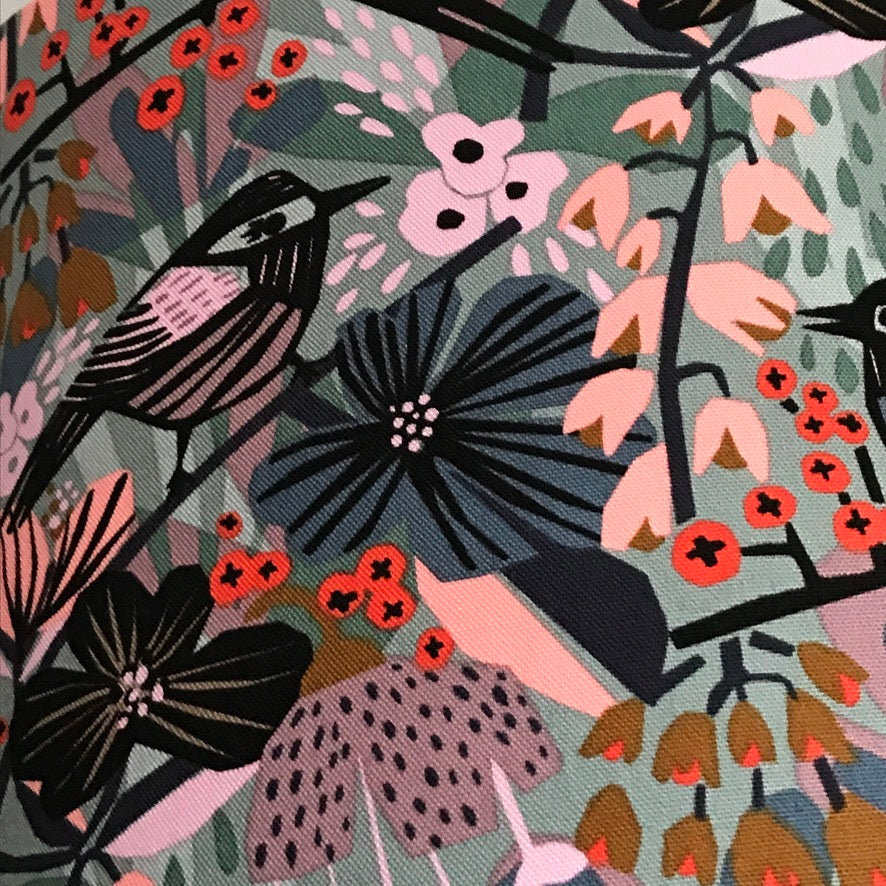 Canvas fabric with black birds in a pastel pink, blue and grey floral background.