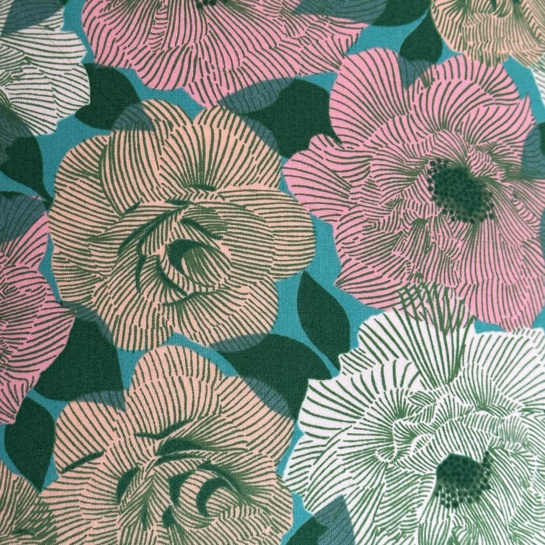 Cotton fabric featuring a green background with white, pink and cream roses