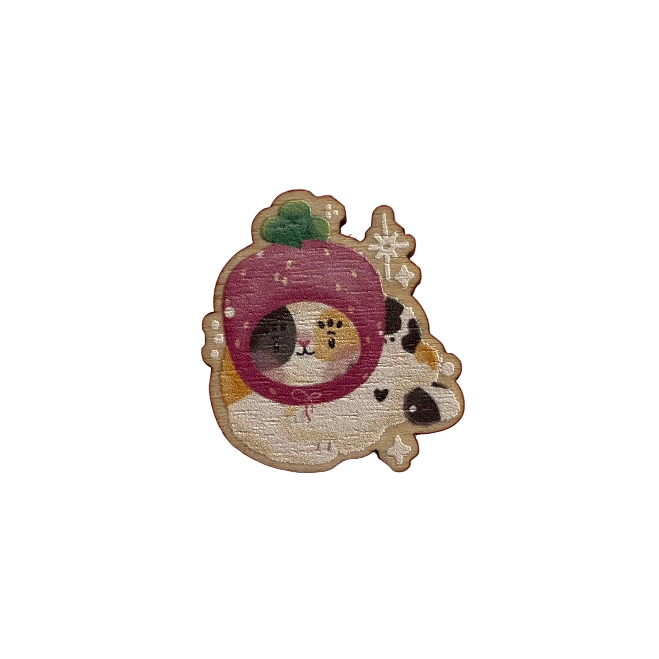 Wooden pin badge of a calico cat wearing a pawberry (heart-shaped strawberries with a paw shape inside) hat. This badge is printed onto 3mm thick responsibly sourced European birch plywood.